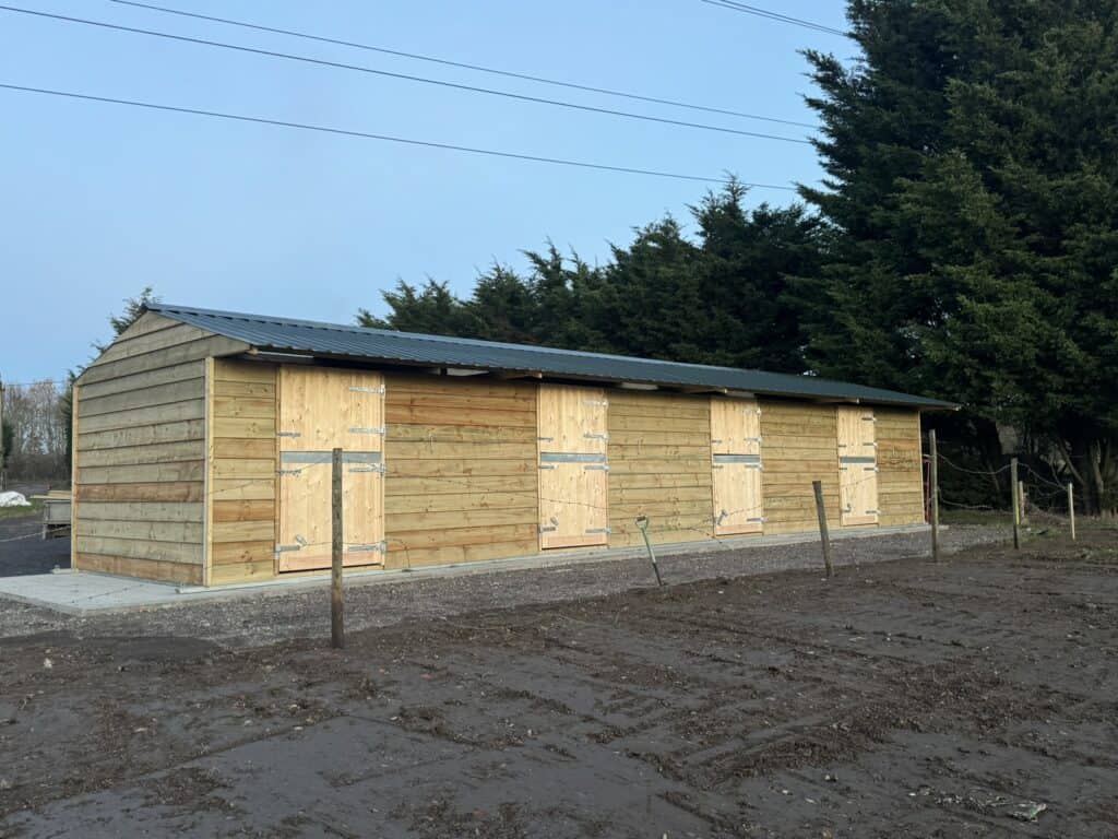 New wooden stable building built by Sussex Stables for horse boarding and equestrian activities. Featuring galvanised steel skids and steel roofing